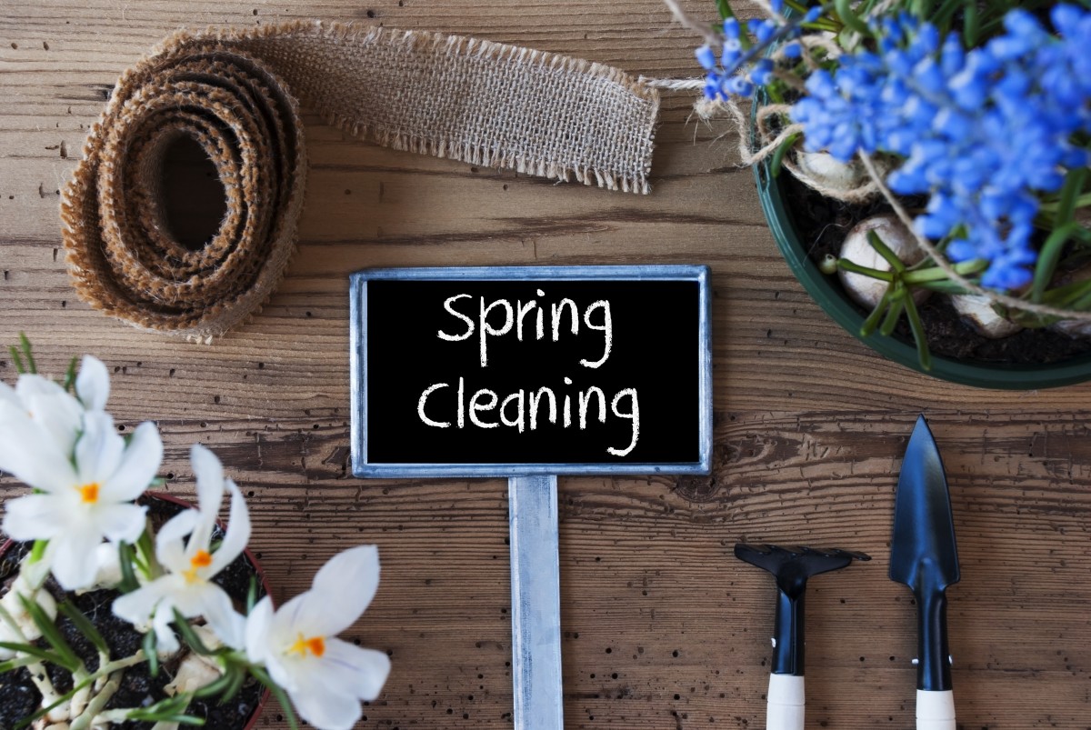 Spring cleaning sign with gardening tools, flowers and ribbon