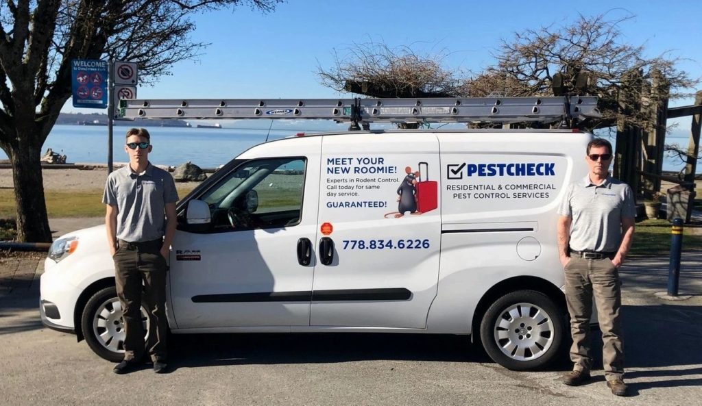 local pest control business in West Vancouver. Van with two pest control technicians standing beside it.