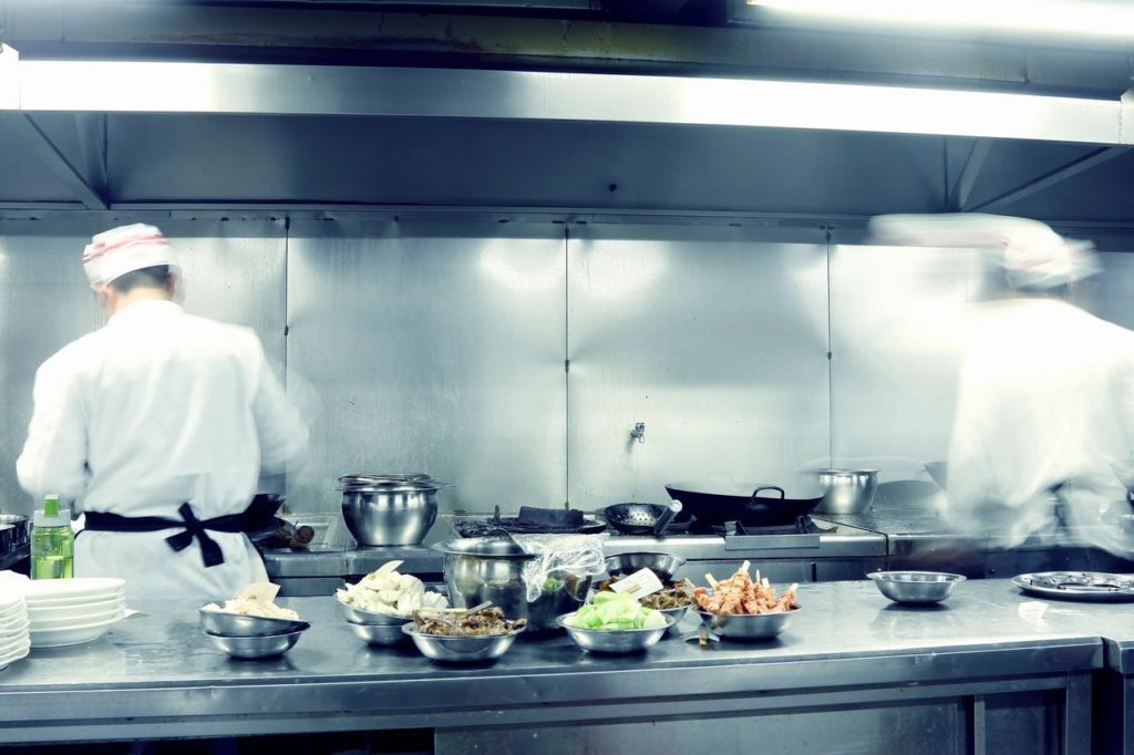 Two chefs working in a commercial kitchen which needs restaurant pest control