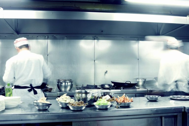 Two chefs working in a commercial kitchen which needs restaurant pest control